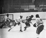 10 Caught in the act! Grant Bennett, Bruin defenceman, hooks Seneca Braves’ Doug Menard (21) as he pursues the puck in front of Sheridan goal-tender Ross Barkwell. Bruin’s Tom Daley (16) looks on. Bennett received a penalty on the play. by Bob McCrudden
